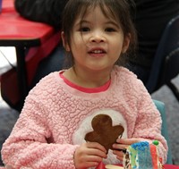 student holding gingerbread cookie