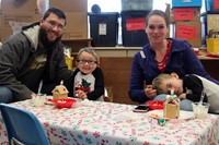 people smiling next to gingerbread houses