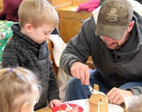 two people working on gingerbread house