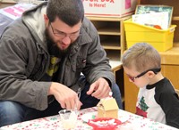 two people creating gingerbread house