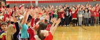 students singing with hands in the air