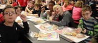 students displaying place mats and friendship bracelets