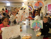 students holding up place mats and friendship bracelets