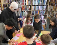 people at table working on monster crafts