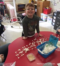 student smiling next to 100 days of school activity