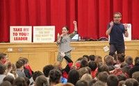 student singing in front of assembly