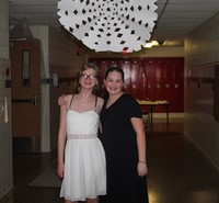 two students smiling by snowflake cut out