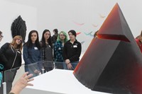 students looking at glass sculpture on display