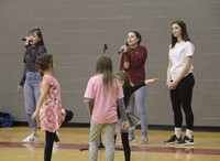 elementary students watching high school students sing