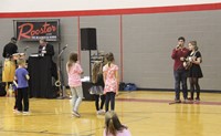 elementary students watching high school students sing