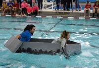 two students competing in cardboard boat races