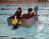 two students competing in cardboard boat races