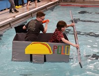 two students competing in cardboard boat races