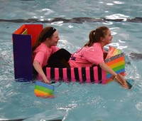 two students competing in cardboard boat races