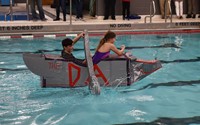 two students competing in cardboard boat races