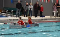 two students competing in cardboard boat races