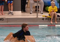 student competing in cardboard boat races