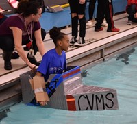 student competing in cardboard boat races