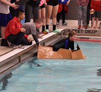 student competing in cardboard boat races