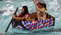 two students competing in cardboard boat races