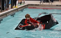 student competing in cardboard boat races
