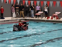 student competing in cardboard boat races