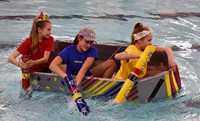 three students competing in cardboard boat races