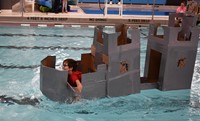 student competing in cardboard boat races