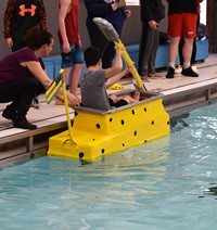 student competing in cardboard boat races