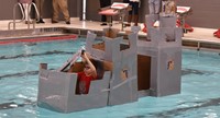 student competing in cardboard boat races