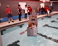 student competing in cardboard boat races