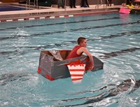 student competing in cardboard boat races