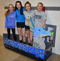 students standing in their cardboard boat