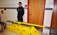 student standing with cardboard boat