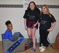 three students with their cardboard boat