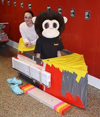 two students sitting with their cardboard boat