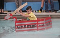 student competing in cardboard boat race