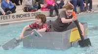 two students competing in cardboard boat race