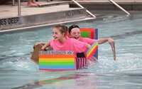 two students competing in cardboard boat race