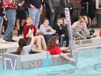 two students competing in cardboard boat race