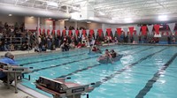 wide shot of students competing in cardboard boat race