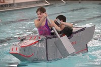 two students competing in cardboard boat race
