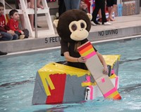 student competing in cardboard boat race