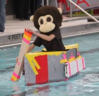 student competing in cardboard boat race