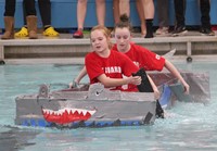 two students competing in cardboard boat race