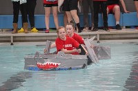 two students competing in cardboard boat race