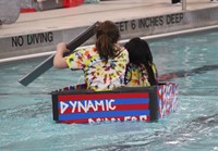 two students competing in cardboard boat race