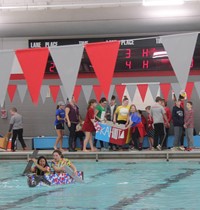 wide shot of two students competing in cardboard boat race
