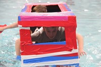 two students competing in cardboard boat race