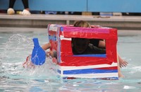 two students competing in cardboard boat race